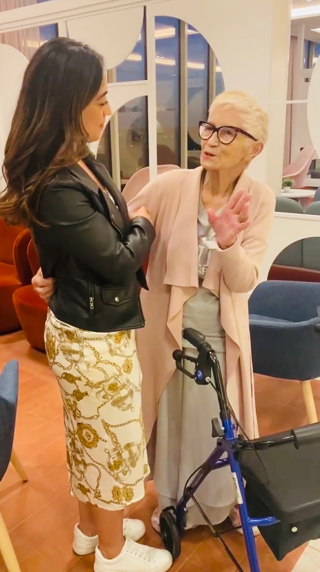 Support worker assisting an older woman with a walking frame